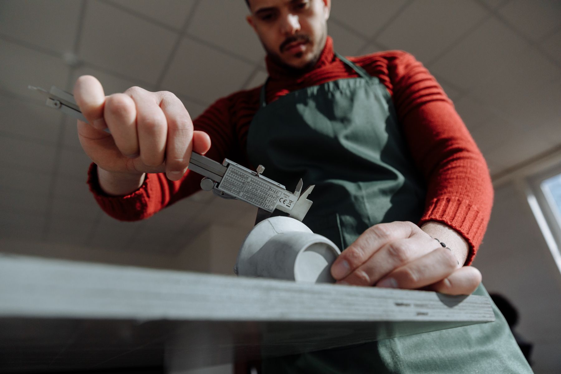 Profesional midiendo una pieza con un calibre